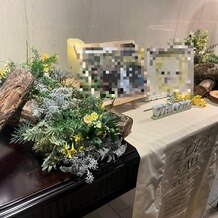 ウエディングヒル　東京ベイ幕張の写真｜ウェルカムスペースの机。周囲の装花と敷いてあるクロスは会場の備品。
