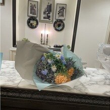 ベイサイド迎賓館　松山の画像｜挙式前にサプライズで新郎から新婦への花束のプレゼントで青メイン色の花がとても綺麗