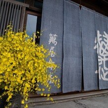 萬屋本店－ＫＡＭＡＫＵＲＡ　ＨＡＳＥ　ｅｓｔ１８０６－の画像｜入り口のお花