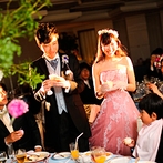 ホテルニューオータニ大阪：テーマカラーに合わせたピンクのドレスにお色直し。キャンドルリレーの演出では、会場全体に優しい光が