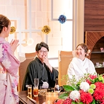 ホテル メルパルク熊本：挙式・披露宴とも和婚のイメージで統一。メイン席を彩る鮮やかな紅白の装花もふたりの笑顔を引き立てた
