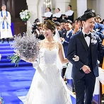 アニヴェルセル 大阪：純白のドレスがくっきりと映えるロイヤルブルーのバージンロード。感動の挙式後は晴れやかな笑顔で退場！