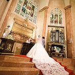 マリエカリヨン名古屋：純白の花嫁が父とバージンロードを歩いて祭壇へ。厳粛な光と美しい音楽に包まれ、新郎との誓いを新たにした