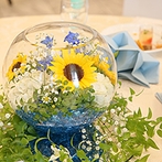 ＫＩＯＫＵＮＯＭＯＲＩ　（記憶の森）：ヒマワリが咲き誇るガラスの装花、ブルーのテーマカラーが夏らしさを演出。最後は映像を使ったプロポーズも