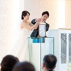 ル・センティ フォーリア 大阪：ステンドグラスが美しい純白のチャペルでの挙式。ゲストが参加するサンドセレモニーでふたりらしく誓った