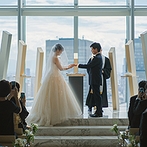 The 33 Sense of Wedding（ザ・サーティスリー センス・オブ・ウエディング）：大阪都心の街並みを望む大きな窓が、誓いのシーンでオープン。笑いあり感動ありの温かな挙式に