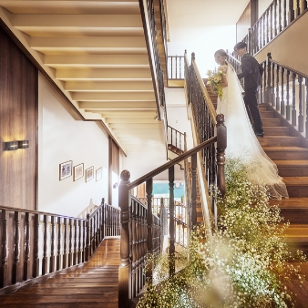 ザ・ロイヤルダイナスティ大宮（THE ROYAL DYNASTY OMIYA）:【26年10月～11月】＼60名83万円分特典／挙式料特典プレゼント オータムプラン:【和洋文化が紡ぐ美空間】光と緑の温もり溢れる全天候型チャペルで無垢な誓いを大宮駅から専用バスで5分の好立地！クラシカルな上品さとモダンな雰囲気が調和した空間は、自然体のW（ウエディング）が叶う。挙式は、厳かな館内神殿か、柔らかな光の館内チャペル。披露宴は異なる印象の2会場から選べ、季節や天候を問わず特別な一日を。