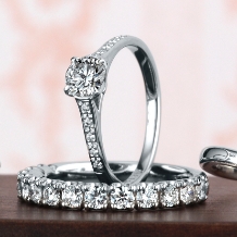 細身のラインに敷き詰められた沢山のダイヤがセンターダイヤを大きく輝かせる婚約指輪