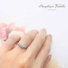 アンジェリック　フォセッテ　ブライダル:メインのダイヤモンドを包み込むセッティングと寄り添うメレダイヤが優しい雰囲気に！