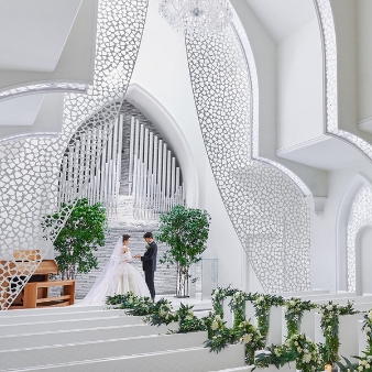 ステラ・デル・アンジェロ（Stella dell'Angelo）:【2026年9月～11月☆最大85万円優待】人気の秋ウエディングも今だけお得に優待♪◆ゼクシイ限定:まっ白に統一された誓いの舞台は、天使の星という意味を持つ大聖堂「サント・ジオバーニ」。１０ｍにおよぶ高天井と広い空間はげゲストに安心感を与えてくれる。チャペルのソファは過ごしやすい柔らかなソファを使用。【壮大なスケールを誇る大聖堂に一目惚れする花嫁がたくさん