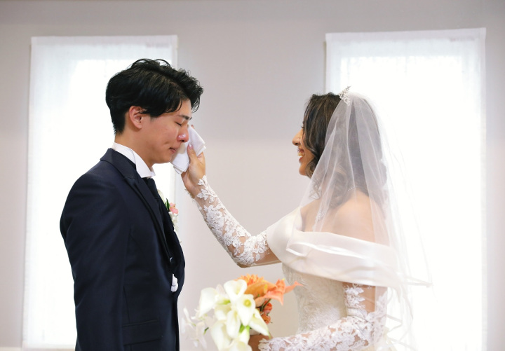 新郎の涙を拭う花嫁