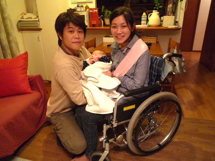 車いすユーザーの妻と夫が、赤ちゃんをだっこしている写真