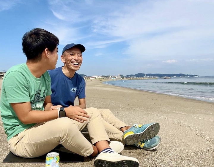 ビーチで寛ぐ同性カップルの写真