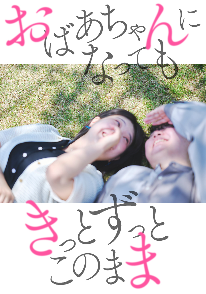 芝に寝転ぶカップルの写真