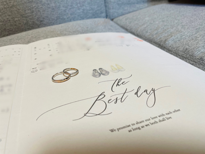 新郎新婦の靴がイラストで描かれ、The Best dayの流れるような書体が大きく描かれたデザインに、指輪を２つ並べて撮影している。