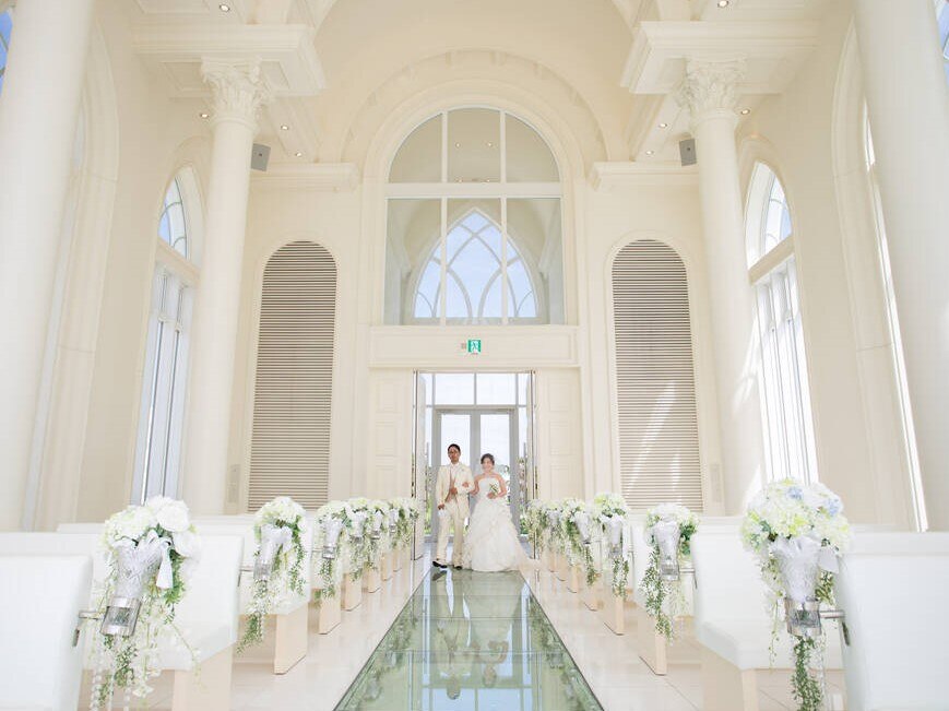 海に続くバージンロードを２人腕を組んで入場