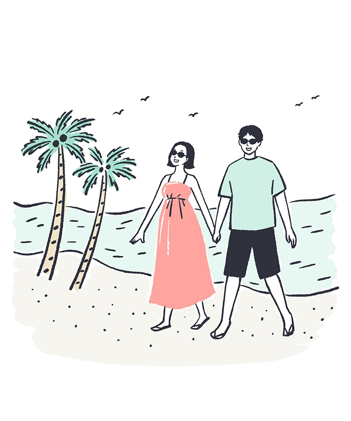ハワイの海辺を歩くカップル